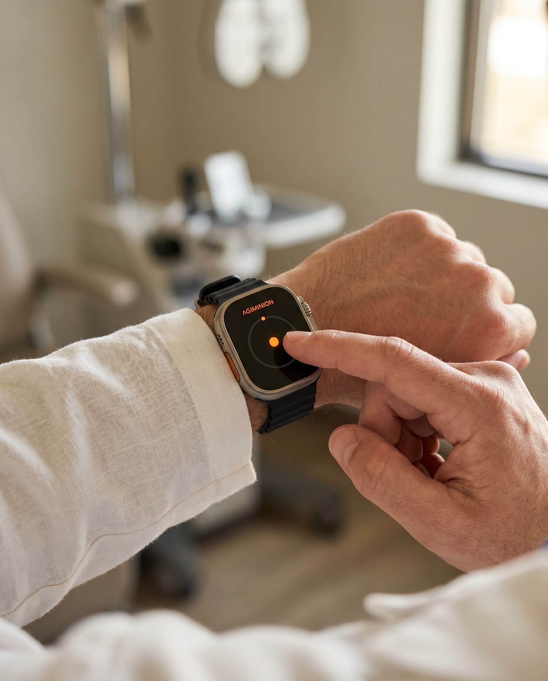 Provider tapping an AGIMINION watch concept in an exam room.